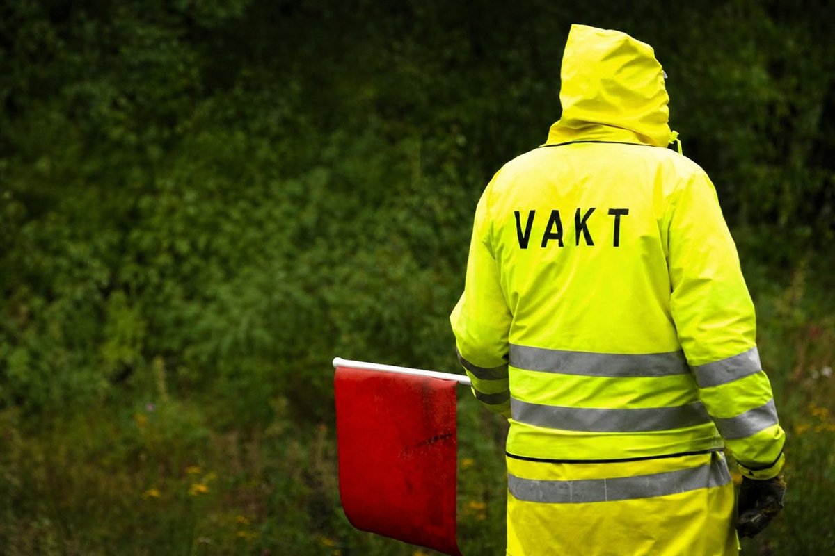 Flaggvakt som dirigerar trafiken vid ett vägarbete i Skåne